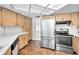 Well-lit kitchen with wooden cabinets, stainless steel appliances, and tile flooring at 3411 Glossy Ibis Ct, Palm Harbor, FL 34683