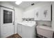Clean laundry room with washer, dryer, utility sink and cabinets for storage. Tile floor at 3411 Glossy Ibis Ct, Palm Harbor, FL 34683