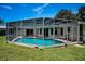 Screened pool with clear blue water, surrounded by a well-maintained lawn and accessible from the home at 3411 Glossy Ibis Ct, Palm Harbor, FL 34683