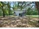 Home's backyard features lush trees and a deck with outdoor seating at 34147 Ringwalt Dr, Dade City, FL 33523