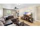 Cozy living room featuring a comfortable sectional, modern TV console, and light wood-look floors at 34147 Ringwalt Dr, Dade City, FL 33523