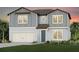 Charming two-story home with a gray exterior, a two car garage, and a well-manicured lawn at 36458 Sespe Creek Ct, Zephyrhills, FL 33540