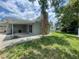View of the backyard of this home with a stone chimney, patio, and grassy area at 3803 43Rd N Ave, St Petersburg, FL 33714