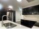 Bright kitchen features stainless steel refrigerator, dark cabinetry, quartz counters and stainless steel sink at 3803 43Rd N Ave, St Petersburg, FL 33714
