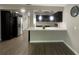 Modern kitchen featuring dark cabinetry, stainless steel appliances, breakfast bar, and dark wood flooring at 3803 43Rd N Ave, St Petersburg, FL 33714