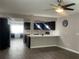 Open-concept living space featuring modern kitchen with dark cabinets, stainless appliances, and ceiling fan at 3803 43Rd N Ave, St Petersburg, FL 33714