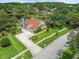 Aerial shot showcasing a beautifully landscaped home with a long driveway, mature trees and a backyard pond at 4118 Carrollwood Village Dr, Tampa, FL 33618