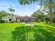 Expansive backyard featuring a screened-in pool area with a beautiful lawn at 4118 Carrollwood Village Dr, Tampa, FL 33618