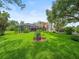 Spacious backyard featuring lush green grass, landscaping, and a covered pool, perfect for outdoor entertaining at 4118 Carrollwood Village Dr, Tampa, FL 33618