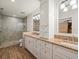 Well-lit bathroom with dual sinks, granite countertops, modern fixtures, and a tiled glass shower at 4118 Carrollwood Village Dr, Tampa, FL 33618