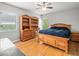 Cozy bedroom featuring hardwood floors, natural light, a ceiling fan, and wooden furniture at 4118 Carrollwood Village Dr, Tampa, FL 33618