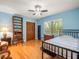 Comfortable bedroom with hardwood floors, built-in shelves, and a bright window overlooking lush greenery at 4118 Carrollwood Village Dr, Tampa, FL 33618