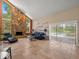 Bright living room with a stone fireplace and views of the screened-in pool area at 4118 Carrollwood Village Dr, Tampa, FL 33618