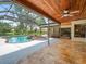 Backyard featuring a screened-in pool, outdoor seating area, and stone-tiled patio, perfect for entertaining at 4118 Carrollwood Village Dr, Tampa, FL 33618