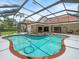 A covered pool area featuring a pristine pool with a built-in spa and mature tropical landscaping at 4118 Carrollwood Village Dr, Tampa, FL 33618