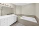 Bathroom featuring a soaking tub with tile surround, and vanity with sink at 423 150Th Ave # 1501, Madeira Beach, FL 33708