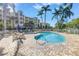 Community pool with a spa, surrounded by trees and community buildings in the background at 423 150Th Ave # 1501, Madeira Beach, FL 33708