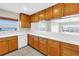 Kitchen with a view includes a white dishwasher, wooden cabinets and light countertops at 423 150Th Ave # 1501, Madeira Beach, FL 33708