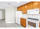 Functional kitchen featuring white appliances, wood cabinets, and tiled floor at 423 150Th Ave # 1501, Madeira Beach, FL 33708