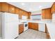 Kitchen with white appliances, granite countertops, hardwood cabinets and tile flooring at 423 150Th Ave # 1501, Madeira Beach, FL 33708