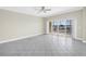 Bright living room with ceiling fan and glass doors to a balcony showcasing water and neighborhood views at 423 150Th Ave # 1501, Madeira Beach, FL 33708