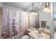 Nautical-themed bathroom featuring a shower with decorative curtain and pendant lighting at 4279 Newport Dr, Hernando Beach, FL 34607