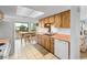 Functional kitchen area featuring wooden cabinets, white appliances, tile floors, and dining area with water views at 4279 Newport Dr, Hernando Beach, FL 34607