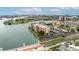Aerial view of multi-story building complex surrounded by waterways, roadways, and green spaces at 450 Treasure Isle Causeway # 411, Treasure Island, FL 33706