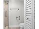 Bathroom featuring a white toilet, tiled shower with grab bar, and white shuttered closet at 450 Treasure Isle Causeway # 411, Treasure Island, FL 33706
