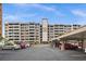 Multi-story condo building featuring balconies, covered parking, and well-maintained landscaping at 450 Treasure Isle Causeway # 411, Treasure Island, FL 33706