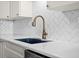 Kitchen featuring a modern faucet, herringbone backsplash, and white countertops and cabinets at 450 Treasure Isle Causeway # 411, Treasure Island, FL 33706