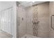 Tiled shower with glass door, grab bars, and integrated showerhead; white louvered closet doors nearby at 450 Treasure Isle Causeway # 411, Treasure Island, FL 33706