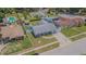 Aerial view of a charming neighborhood home with a well-maintained lawn, long driveway, and mature trees at 4518 Ashmore Dr, Tampa, FL 33610