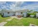 Private backyard area featuring a patio with an outdoor dining set, greenery, and a partially fenced-in area at 4518 Ashmore Dr, Tampa, FL 33610