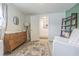 This Bedroom features an area rug, dresser, glider, and a door leading to a hall with decorative poster at 4518 Ashmore Dr, Tampa, FL 33610