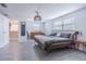 Bright bedroom features wood-style tile floor, natural light from two windows, a walk-in closet and designer light fixture at 4518 Ashmore Dr, Tampa, FL 33610