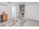 Bright bedroom features a custom closet, cabinets, and a stylish accent rug over gray wood-look tile flooring at 4518 Ashmore Dr, Tampa, FL 33610