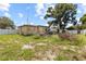 A backyard with grass, a small deck, a white fence, and house in the background at 525 38Th S St, St Petersburg, FL 33711