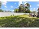 A backyard with grass, a white fence, and a small deck with equipment at 525 38Th S St, St Petersburg, FL 33711