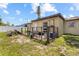 A backyard with grass, a small deck, a white fence, and house in the background at 525 38Th S St, St Petersburg, FL 33711
