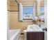 Cozy bathroom featuring a bathtub, sink, and tiled walls, bathed in natural light from the window at 525 38Th S St, St Petersburg, FL 33711