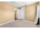 A cozy bedroom with neutral carpet, fan, closet and doorway to another room at 525 38Th S St, St Petersburg, FL 33711