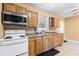 Spacious kitchen featuring essential appliances, wooden cabinetry, and tile floors at 525 38Th S St, St Petersburg, FL 33711