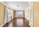 Cozy living room with wood floors, neutral walls, large windows, and a built-in shelving unit at 525 38Th S St, St Petersburg, FL 33711