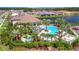 Resort-style community pool and spa with palm trees, lounge chairs, and lush landscaping overlooking the lake at 5320 Morey Farms Loop, Palmetto, FL 34221