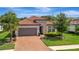 Charming single-story home with a red tile roof, stone accents, and a paved driveway at 5320 Morey Farms Loop, Palmetto, FL 34221