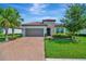 Charming home featuring a terracotta tile roof, brick paved drive, and a two-car garage at 5320 Morey Farms Loop, Palmetto, FL 34221