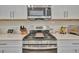 Close-up of a modern kitchen stove with stainless steel appliances and white tile backsplash at 5320 Morey Farms Loop, Palmetto, FL 34221