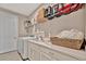 Bright laundry room with washer and dryer, sink, white cabinets, and wire shelving for storage at 5320 Morey Farms Loop, Palmetto, FL 34221
