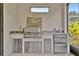 Beautiful outdoor kitchen with stainless steel grill and granite countertops, perfect for entertaining guests at 5320 Morey Farms Loop, Palmetto, FL 34221